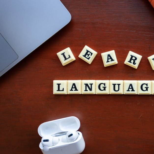 Flat lay of language learning materials with gadgets promoting education.