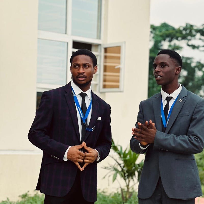 Two young men in formal suits standing outside during a conference in Seriki Sotayo, Ogun State.